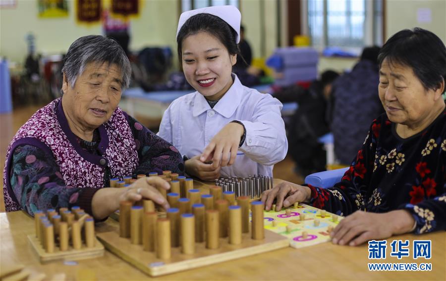 12月28日，武邑县医院医养结合中心康复师（中）帮助老人进行智力训练。