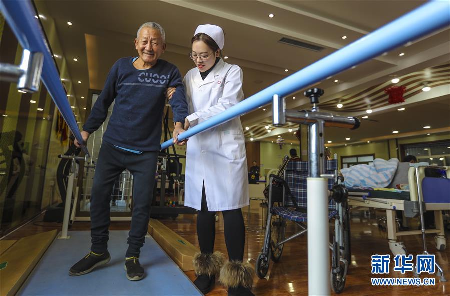 12月28日，武邑县医院医养结合中心康复师（右）帮助老人进行走路恢复训练。