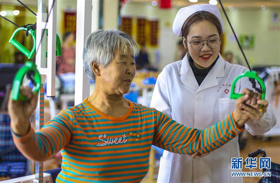 12月28日，武邑县医院医养结合中心康复师（右）在帮助老人进行康复训练。